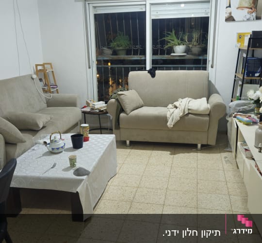 סלון עם ספות וחלונות עם תריסים
